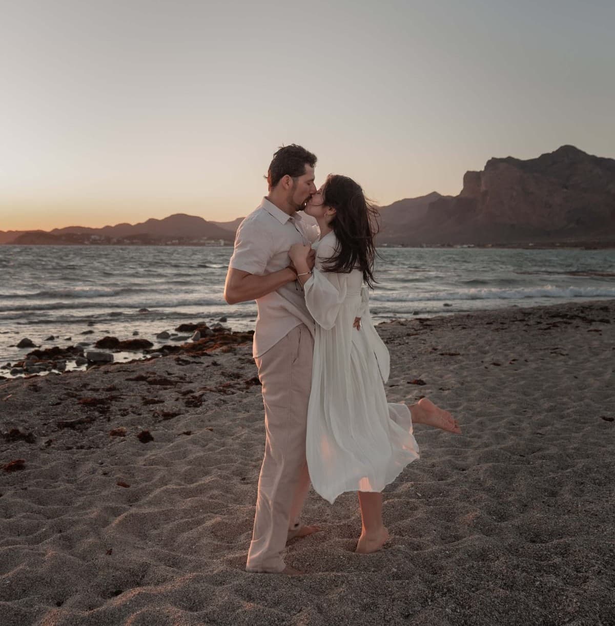 Janeth y Efrain besándose en la playa al atardecer